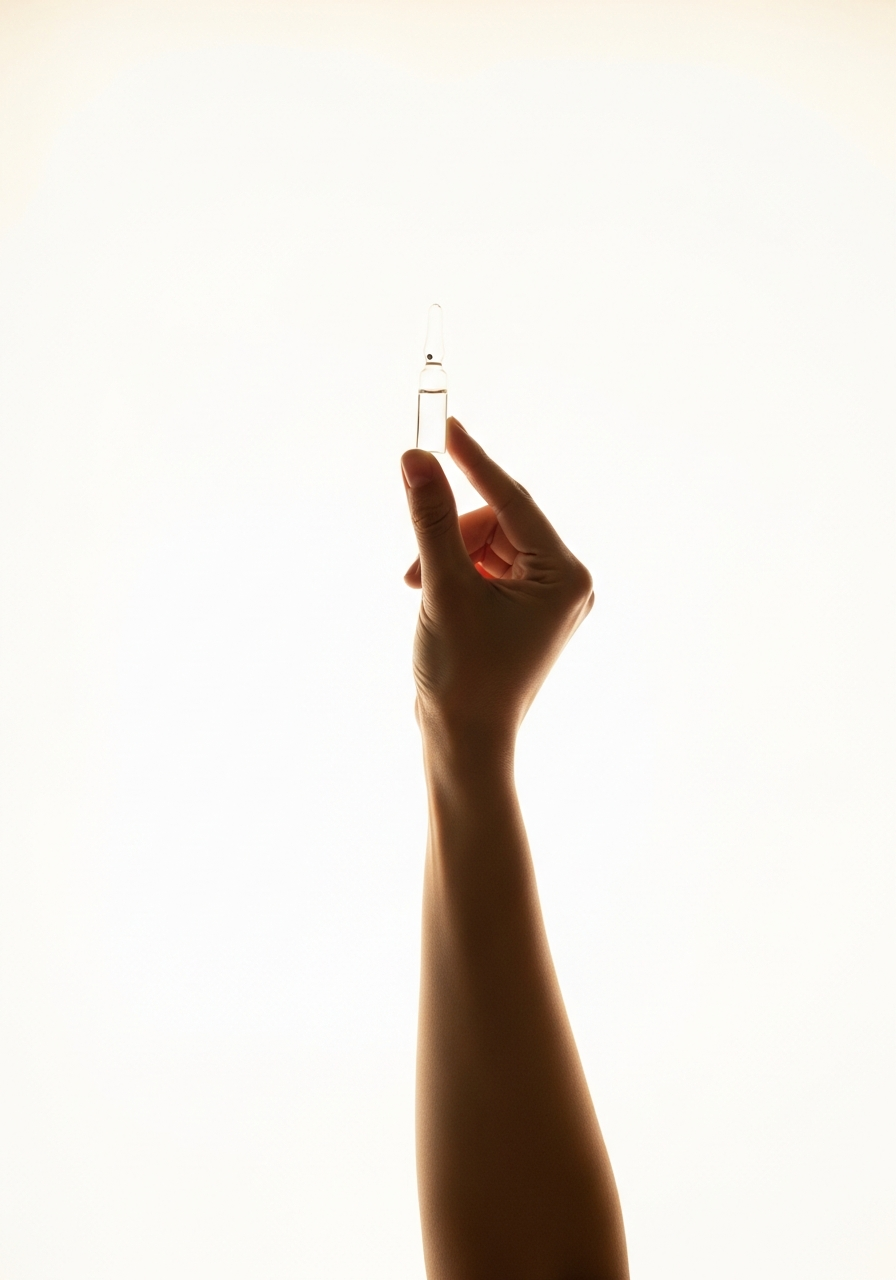 Hand holding a glass vial toward light — ATMP-certified precision